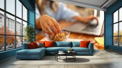 Healthy Snack at Work - Hand Reaching for Nuts on Desk Wall mural