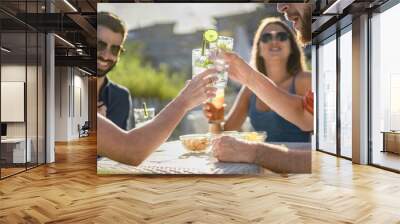 Reunion of best friend toasting with long drinks at the outdoor pub. Happy hour with tropical cocktails at the sunset in the summer. Wall mural