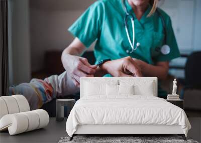 Smartwatch for health care. A woman from the medical health system wears a smartwatch for remote monitoring of vital signs on an elderly person - assisted living concept	 Wall mural