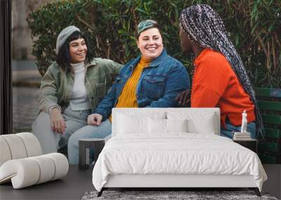 Three diverse friends chatting in the park - Diversity and inclusivity in female friendships Wall mural