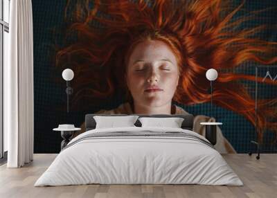 Young freckled redhead woman lying down eyes closed - flat lay concept portrait Wall mural