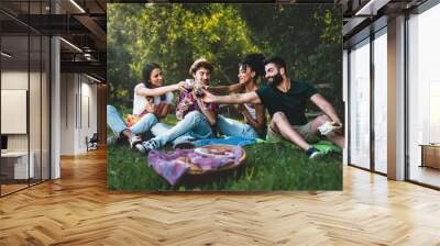 Young people toasting at picnic - Group of friends clinking wine glasses and eating sandwiches   sitting on the grass Wall mural