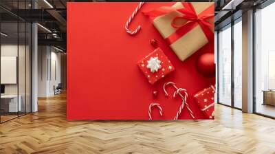 Christmas gifts, baubles ornaments, candy canes decorations. Festive presents composition. Wrapped present boxes flat lay, with copy space on red background. Winter holiday season gift guide concept. Wall mural