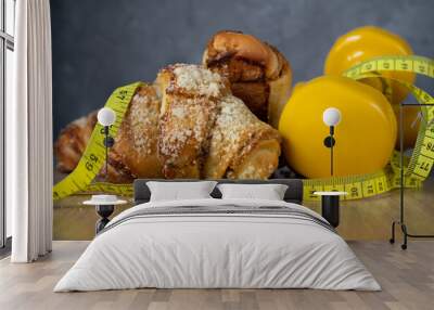 St. Martin's croissant with gym dumbbells, tape measure or measuring tape. Rogal marciński or świętomarciński. Traditional polish pastry with poppy-seed filling and nuts. Healthy diet choice concept. Wall mural