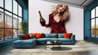 Blithesome cute girl posing after party. Winsome curly woman in red dress drinking wine. Wall mural