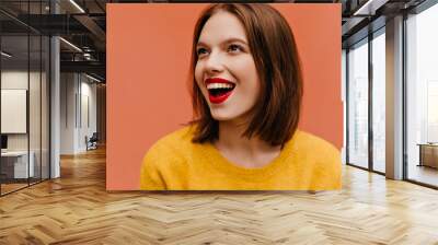 Close-up photo of brunette white girl enjoying life. Studio portrait of laughing carefree woman in yellow outfit. Wall mural