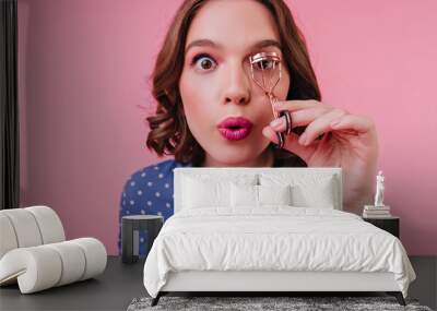 Close-up shot of brown-eyed lady with surprised face expression curls her eyelashes. Studio portrait of lovable caucasian girl with short hair preparing for date. Wall mural