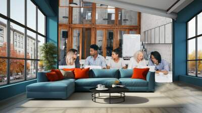 Group of young businesspeople with laptops during meeting Wall mural