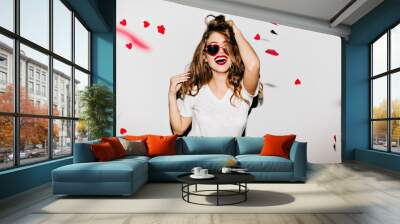 indoor portrait of amazing caucasian female model in trendy t-shirt touching her long shiny hair. la Wall mural