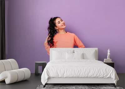 Joyful korean girl posing with hand on hip. Studio shot of stunning asian young lady playing with curly hair. Wall mural