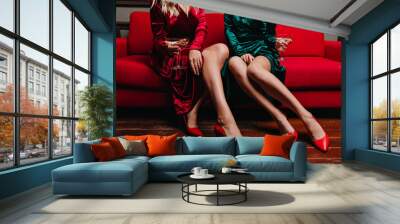 Relaxed elegant women sitting on couch with wineglasses. Amazing slim girls posing after party. Wall mural