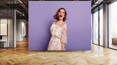 Sensual white woman in summer dress laughing on purple background. Charming female model in romantic clothes smiling during indoor photoshoot. Wall mural