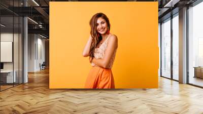 Shy european woman in yellow clothes posing in studio with sincere smile. Spectacular red-haired female model expressing happiness. Wall mural