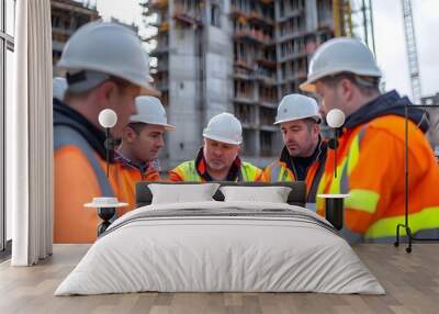 A Group of Construction Workers Examining Blueprints on a Bustling Construction Site Wall mural