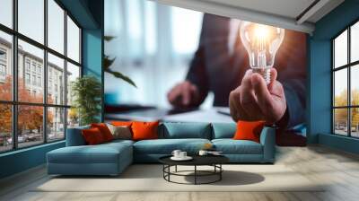 businessman hand holding light bulb with finance document and tool,concept of New ideas for business and fonance. Wall mural