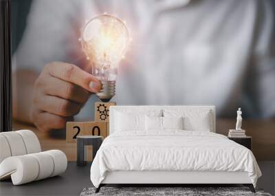 Businessman touching a bright light bulb. 2021 Concept of Ideas for presenting new ideas Great inspiration and innovation new beginning. Wall mural