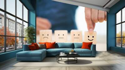 Hand of a businessman chooses a smiley face on wood block cube, The best excellent business services rating customer experience, Satisfaction survey concept Wall mural