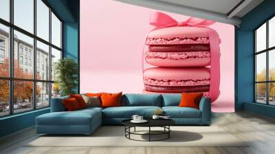 Two pink macarons tied with a ribbon, placed on a soft pink background, presenting a sweet and elegant dessert aesthetic. Wall mural