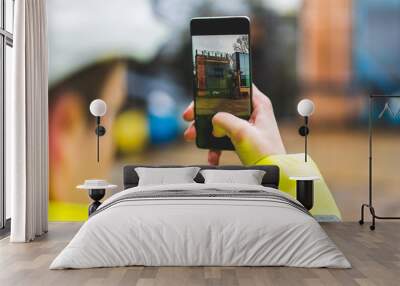 Architect holding a smartphone on construction site - young construction worker is using mobile phone on site - Construction worker with building plans and cellphone - Focus on mobile. warm filter Wall mural