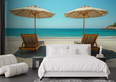 Two wooden lounge chairs and colorful umbrellas facing the ocean on a quiet tropical beach. Wall mural