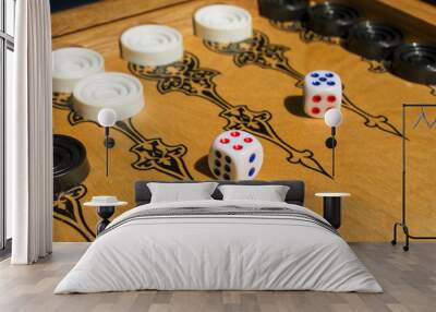 Backgammon, board game. Two cubes, lie on a wooden covering. Black and white details. Background in blur. Wall mural