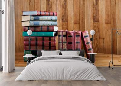 Richly decorated volumes of books with a gold lettering on the b Wall mural