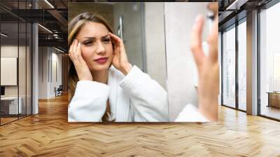 Beautiful woman wearing bathrobe in a bathroom having headache Wall mural