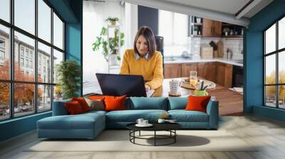 Freelance woman working in home office with laptop computer. Flexible workspace and working time. Wall mural