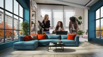 Group of woman entrepreneurs discussing a new project. Female startup business team. A diverse group of businesswomen working at their office Wall mural