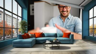 Handsome man having cup of coffee at home in the morning Wall mural