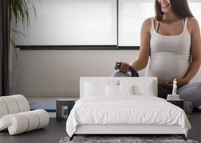 Happy smiling beautiful pregnant woman exercising at home Wall mural