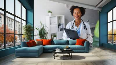 Portrait of female African American doctor standing in her office at clinic Wall mural