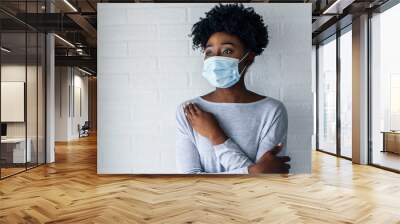 Portrait of young African-American woman wearing disposable medical face mask Wall mural