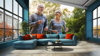 Smiling senior couple jogging in the park Wall mural