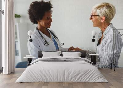 Woman doctor supporting elderly female patient Wall mural