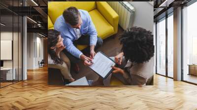 Young married couple signing real estate purchase contract  after consulting with professional broker Wall mural