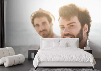 Couple male friends on the beach at sunset Wall mural