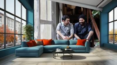 Couple of young men talking on the stairs of an office Wall mural