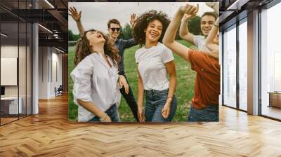 Group of five friends having fun at the park - Millennials dancing in a meadow among confetti thrown in the air - Day of freedom and carefree Wall mural