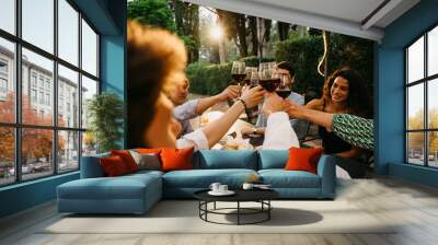 Group of friends outside eat and have fun together toasting with red wine glasses at sunset at the hotel restaurant where are staying - Cheerful people laugh and joke evening  - Party at home Wall mural