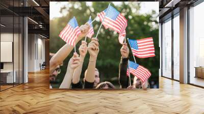 Group of people holds flags of the United States of America USA in the air celebrating citizenship at sunset outdoor - Copy space Wall mural