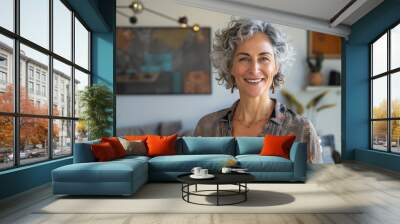  a portrait photo of a smiling confident and happy mature woman standing in her modern apartment Wall mural