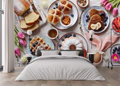 Easter festive dessert table with hot cross buns, cakes, waffles and pancakes. Overhead view Wall mural