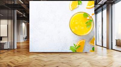 One glass of freshly pressed orange juice with a straw and mint Wall mural