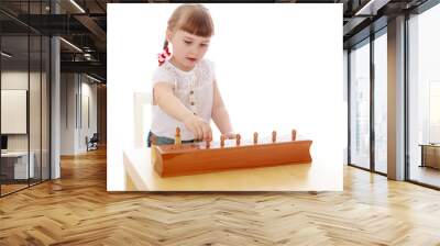 Smart little girl in a Montessori kindergarten sitting at the ta Wall mural