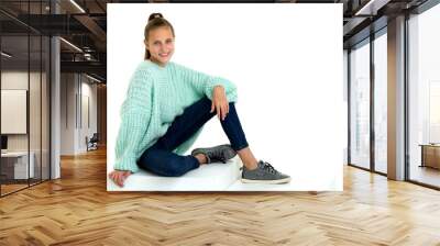 Smiling teenage girl sitting on floor. Isolated over white background. Wall mural