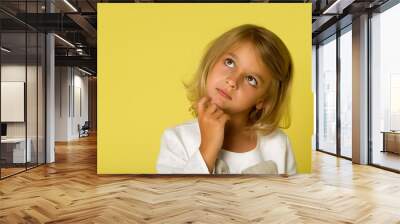 The little girl looks up.The concept of children's emotions. Wall mural