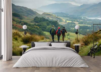 A group of friends smiles as they hike through the beautiful Lake District National Park. Wall mural