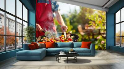 Man in Red Apron Grilling Meat And Vegetables at Summer Garden BBQ Party. Wall mural