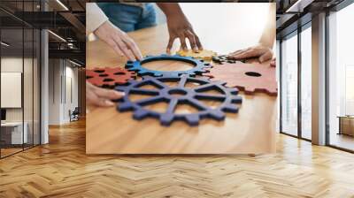 Hands, collaboration and gear with a business team working together in synergy for innovation at a workshop. Meeting, teamwork and creative with a man and woman employee group at work in the office Wall mural